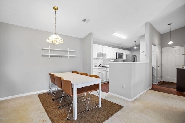 dining space with lofted ceiling, baseboards, and visible vents