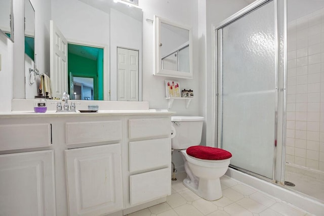 bathroom with toilet, a shower stall, tile patterned flooring, and vanity