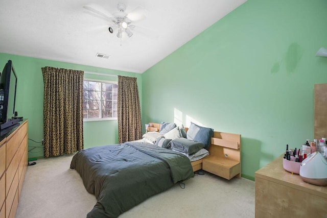 bedroom with light carpet, vaulted ceiling, visible vents, and a ceiling fan