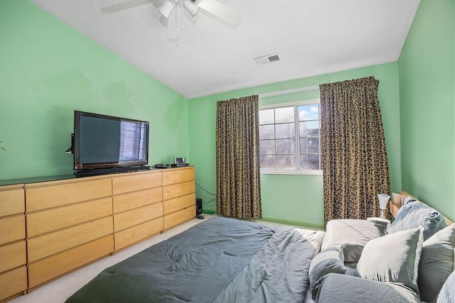 carpeted bedroom featuring a ceiling fan, visible vents, and vaulted ceiling