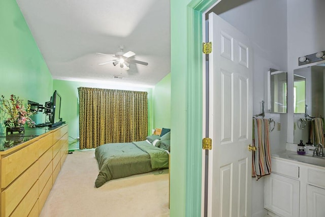 carpeted bedroom featuring a sink, visible vents, and a ceiling fan