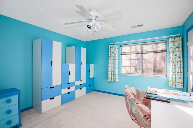 office featuring ceiling fan, visible vents, baseboards, and light colored carpet