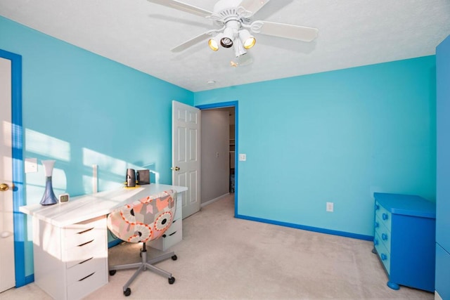 office area featuring a ceiling fan, light carpet, and baseboards