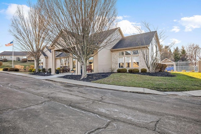 obstructed view of property featuring a front lawn and fence