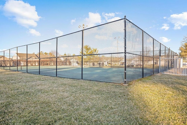 view of sport court featuring fence and a yard