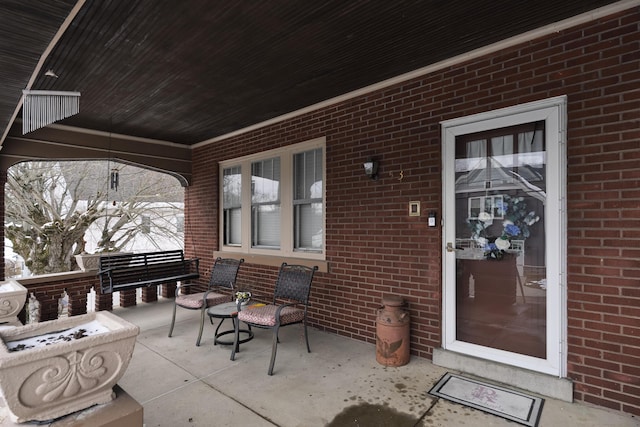 exterior space featuring a porch and brick siding