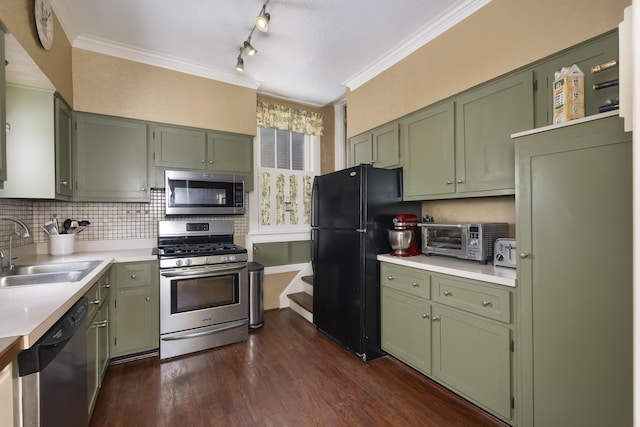 kitchen featuring stainless steel appliances, a sink, light countertops, and green cabinetry