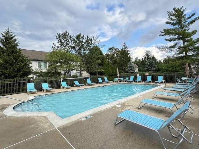 community pool with fence and a patio area