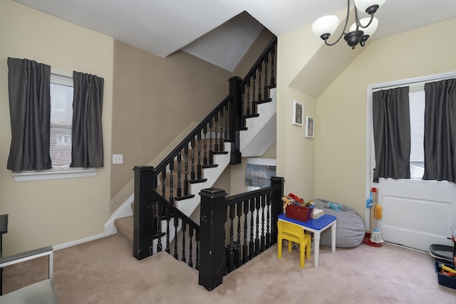 stairway with a chandelier, carpet flooring, and baseboards