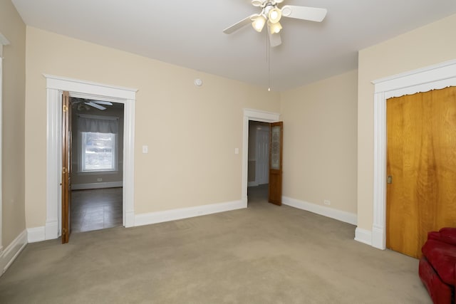 unfurnished bedroom featuring light carpet, ceiling fan, and baseboards