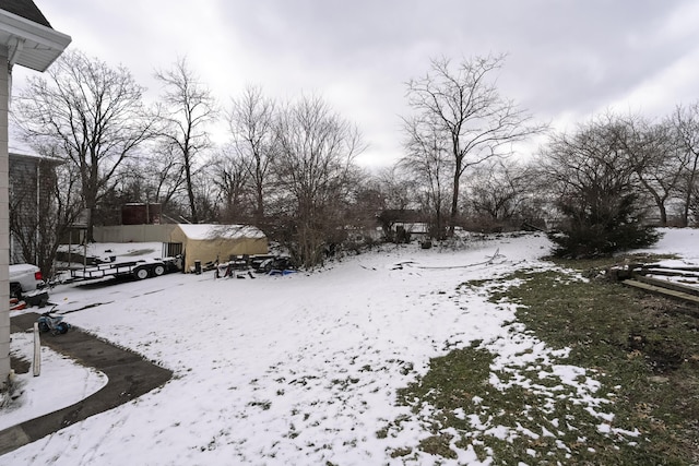 yard covered in snow featuring an outbuilding and a storage shed