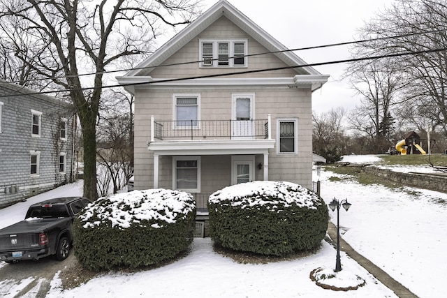 view of front of property with a playground and a balcony