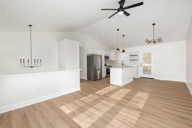 kitchen with open shelves, stainless steel appliances, light countertops, open floor plan, and white cabinetry