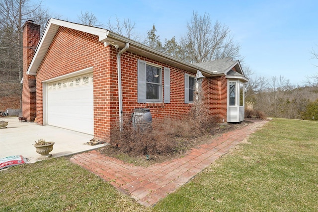 view of home's exterior featuring brick siding, a yard, a chimney, and an attached garage