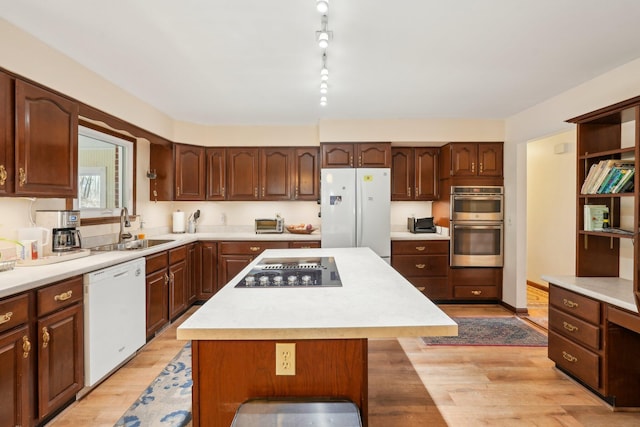 kitchen featuring a center island, white appliances, and light countertops