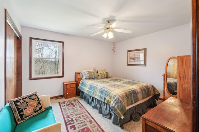 bedroom featuring light carpet, ceiling fan, and baseboards