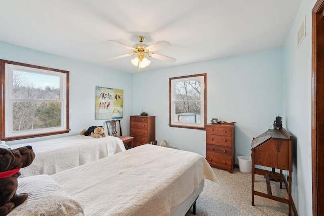 bedroom featuring light carpet, ceiling fan, and visible vents