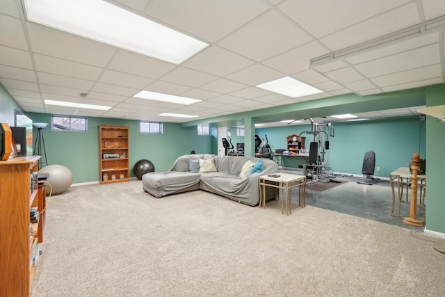 living room featuring a paneled ceiling and baseboards