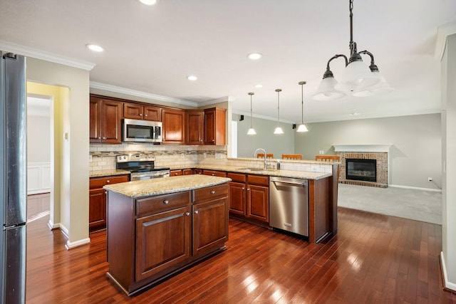 kitchen featuring stainless steel appliances, a peninsula, dark wood-style flooring, and decorative backsplash