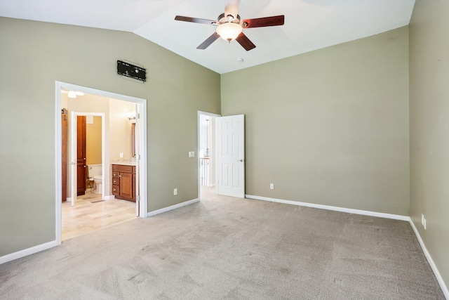 unfurnished bedroom featuring baseboards, light carpet, a ceiling fan, and ensuite bathroom