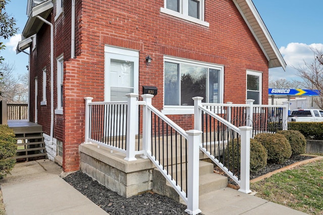 view of exterior entry featuring brick siding