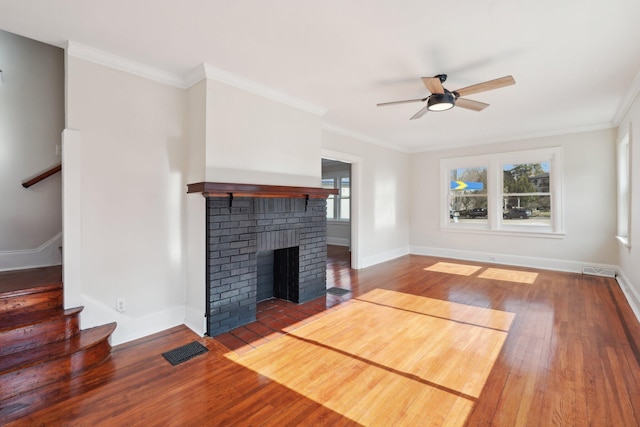 unfurnished living room with visible vents, wood-type flooring, stairway, ornamental molding, and a fireplace