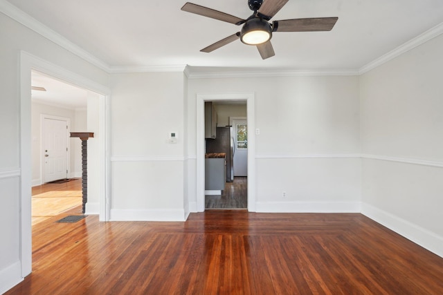 unfurnished room featuring baseboards, wood finished floors, and crown molding