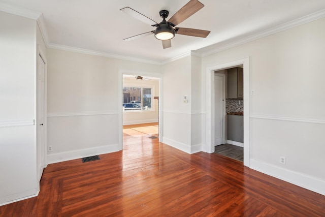 empty room with ornamental molding, visible vents, and wood finished floors