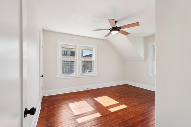 additional living space with hardwood / wood-style flooring, ceiling fan, baseboards, and vaulted ceiling