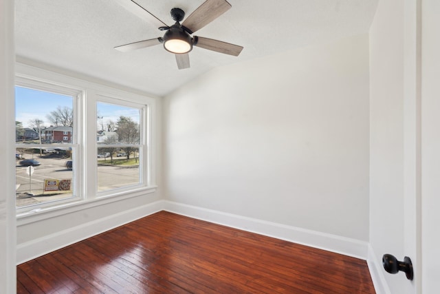 unfurnished room featuring vaulted ceiling, hardwood / wood-style floors, a ceiling fan, and baseboards