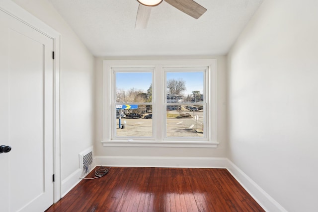 empty room featuring baseboards, visible vents, a ceiling fan, hardwood / wood-style floors, and a textured ceiling