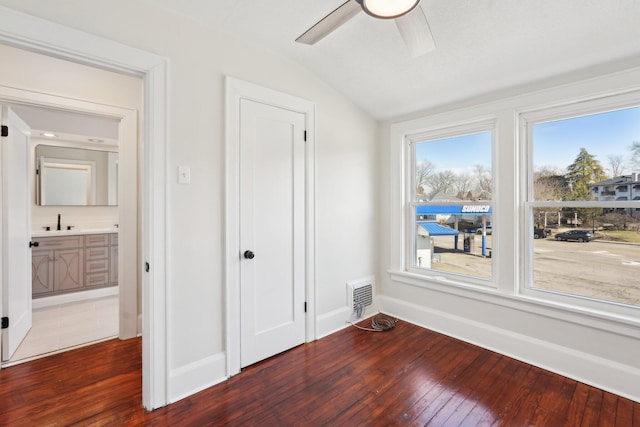 interior space with baseboards, visible vents, vaulted ceiling, and hardwood / wood-style floors