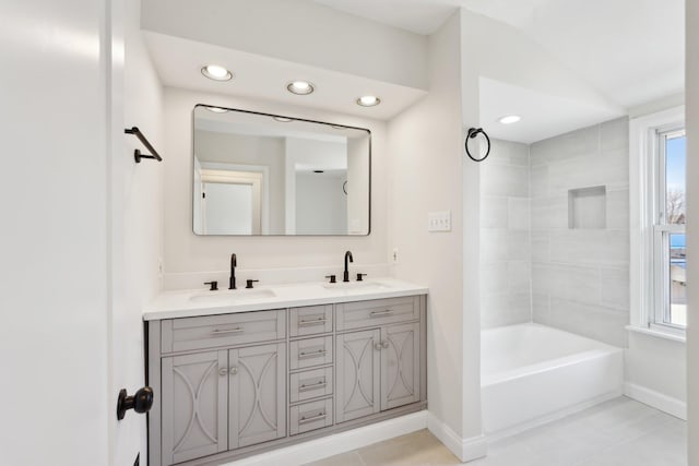 bathroom featuring double vanity, a sink, and baseboards