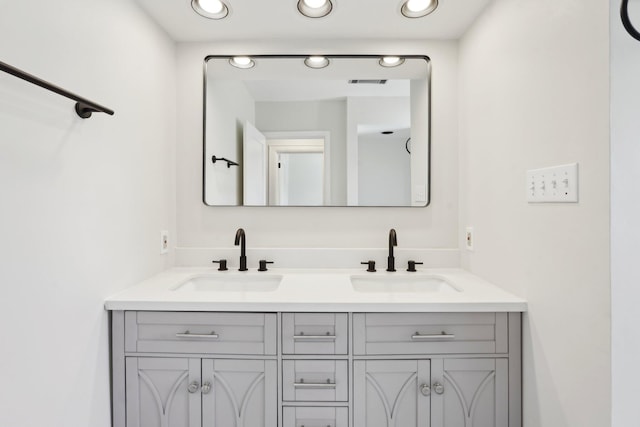 full bath with double vanity, a sink, visible vents, and recessed lighting