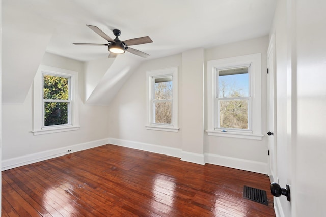 bonus room with lofted ceiling, hardwood / wood-style flooring, a ceiling fan, visible vents, and baseboards