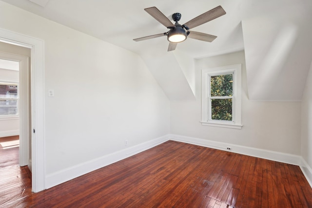 additional living space with a ceiling fan, wood-type flooring, vaulted ceiling, and baseboards