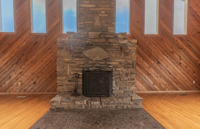 9208 Hawksridge Dr, Covington, KY 41017 - unfurnished living room featuring wood walls, a stone fireplace, and wood finished floors