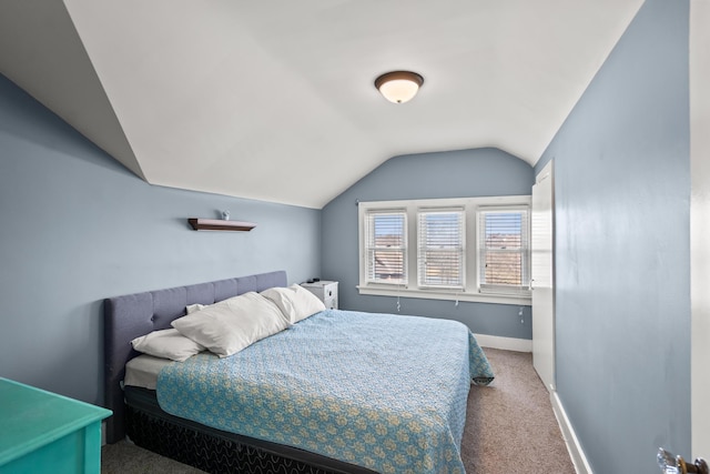 carpeted bedroom featuring vaulted ceiling and baseboards