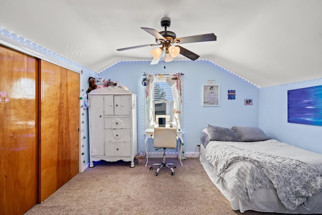 carpeted bedroom with lofted ceiling, a closet, and a ceiling fan