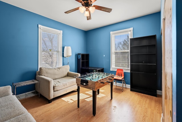 recreation room featuring ceiling fan, baseboards, and wood finished floors