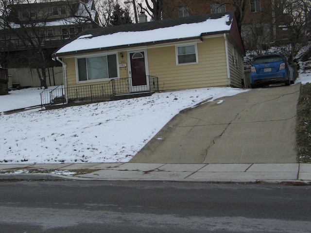 view of front facade featuring driveway and a chimney