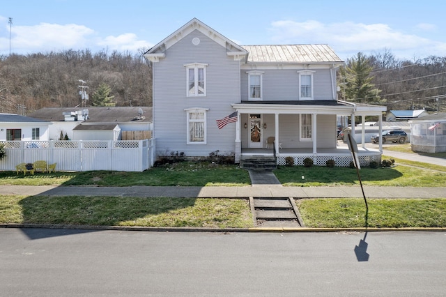 view of front of house with metal roof, a front lawn, fence, and a porch