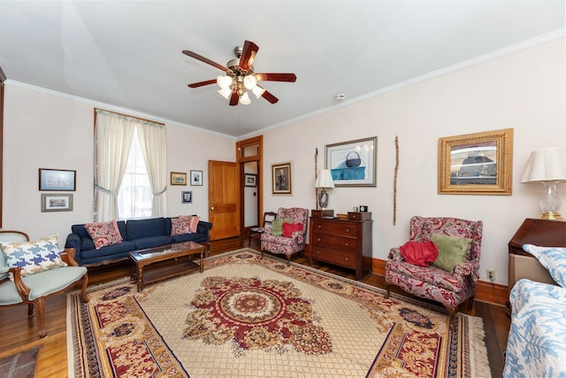 living area featuring a ceiling fan, baseboards, ornamental molding, and wood finished floors