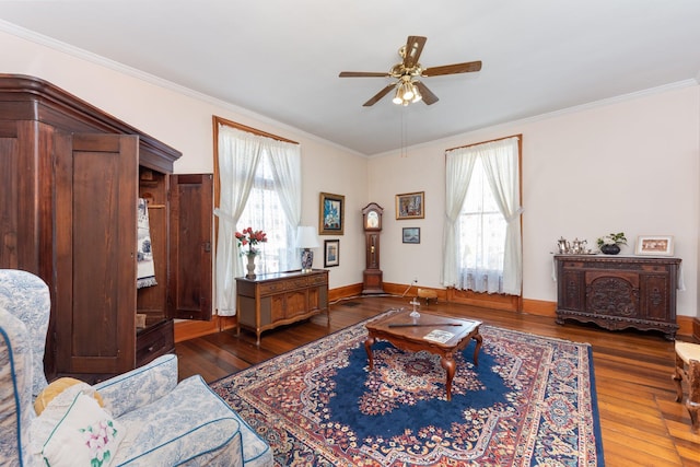 living room featuring baseboards, ceiling fan, ornamental molding, and hardwood / wood-style floors