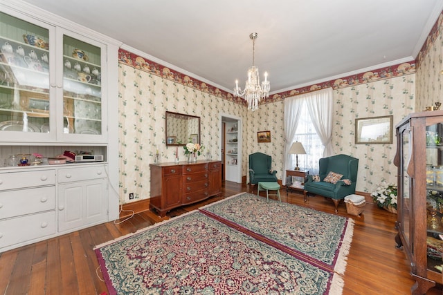 sitting room with baseboards, hardwood / wood-style floors, ornamental molding, and wallpapered walls