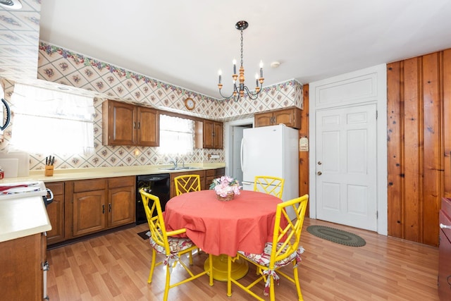 kitchen featuring light countertops, light wood-style flooring, freestanding refrigerator, a sink, and dishwasher