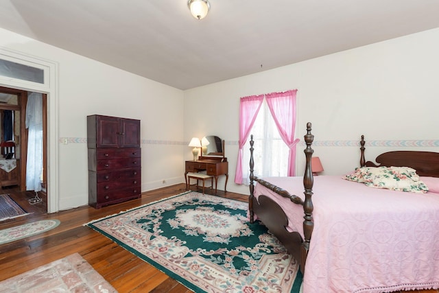 bedroom featuring hardwood / wood-style flooring and baseboards