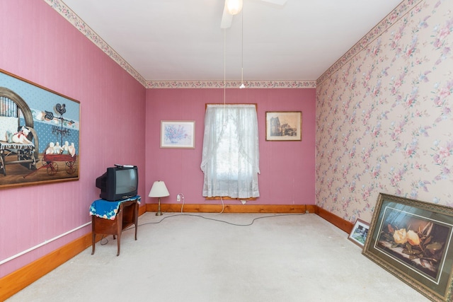 sitting room featuring wallpapered walls, carpet, baseboards, and a ceiling fan