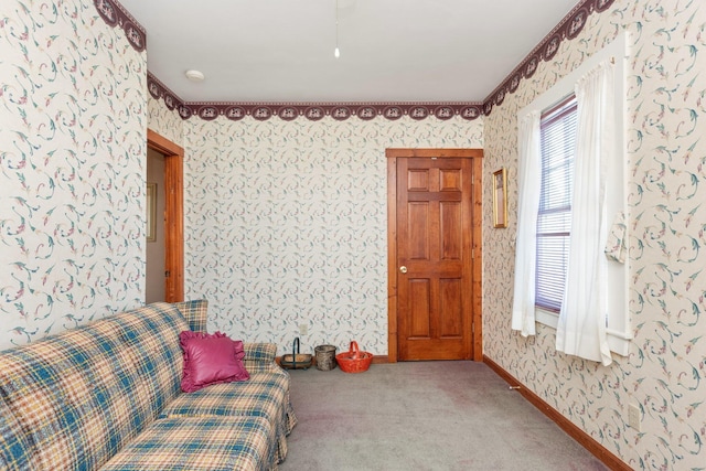 sitting room featuring wallpapered walls, carpet, and baseboards