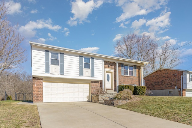 split foyer home with a garage, driveway, brick siding, fence, and a front yard